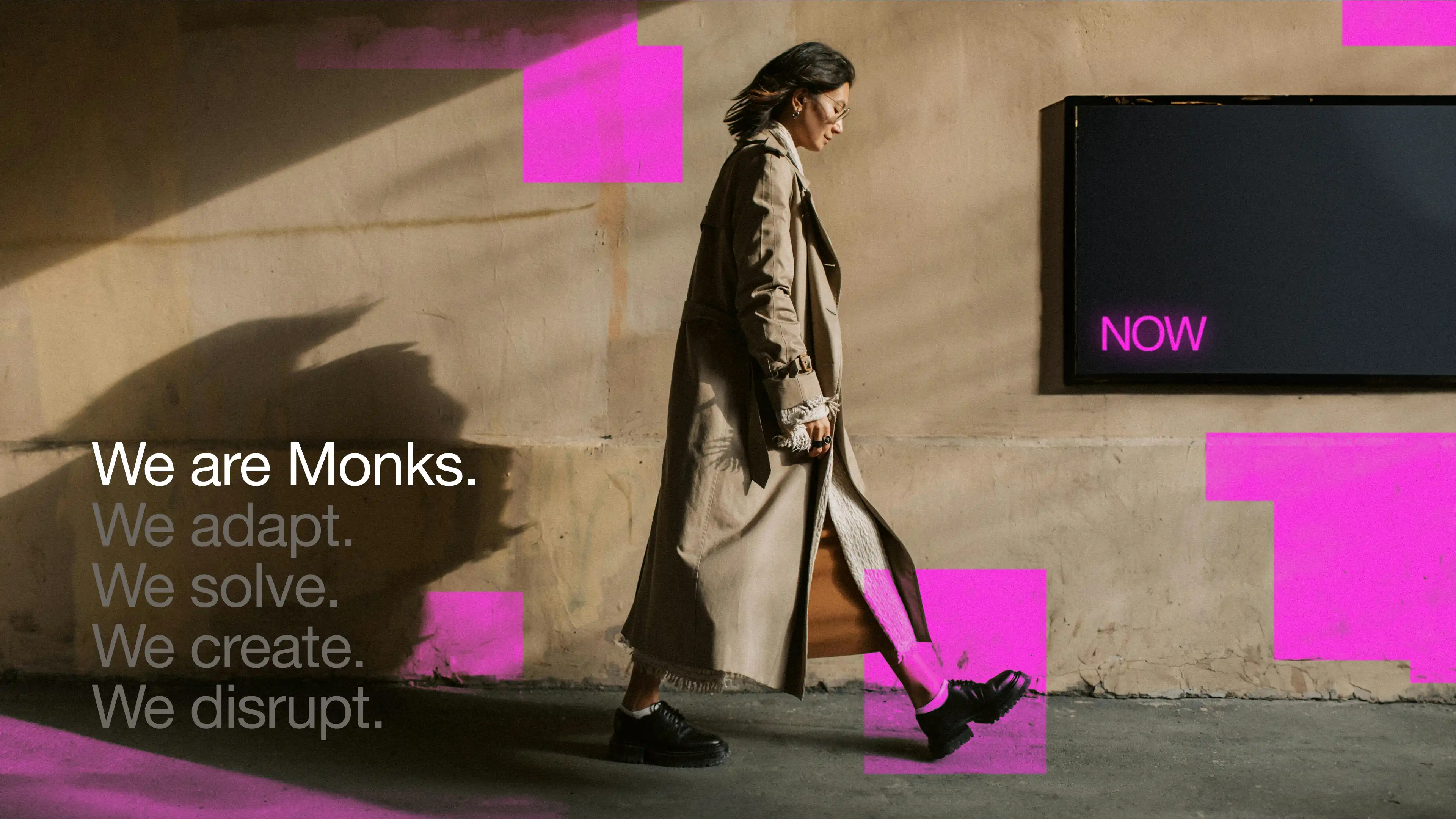 Monks, brand book, we are Monks, we adapt, we solve, we create, we disrupt, over a photo of a woman walking past a wall with magenta blocks